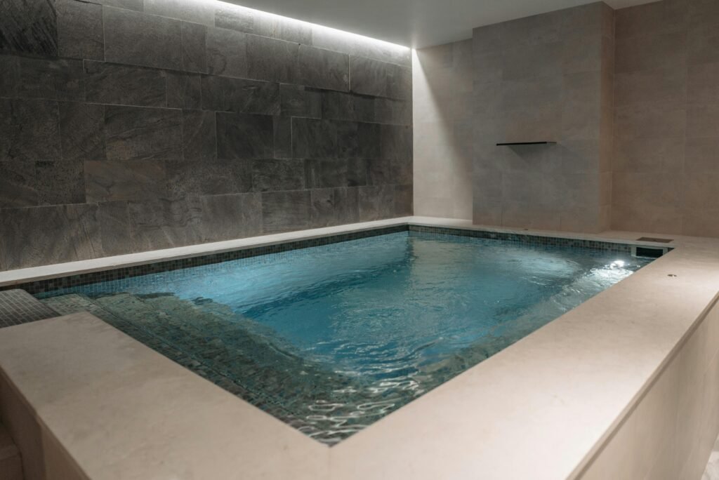 Elegant indoor spa pool with modern stone tile interior, perfect for relaxation.